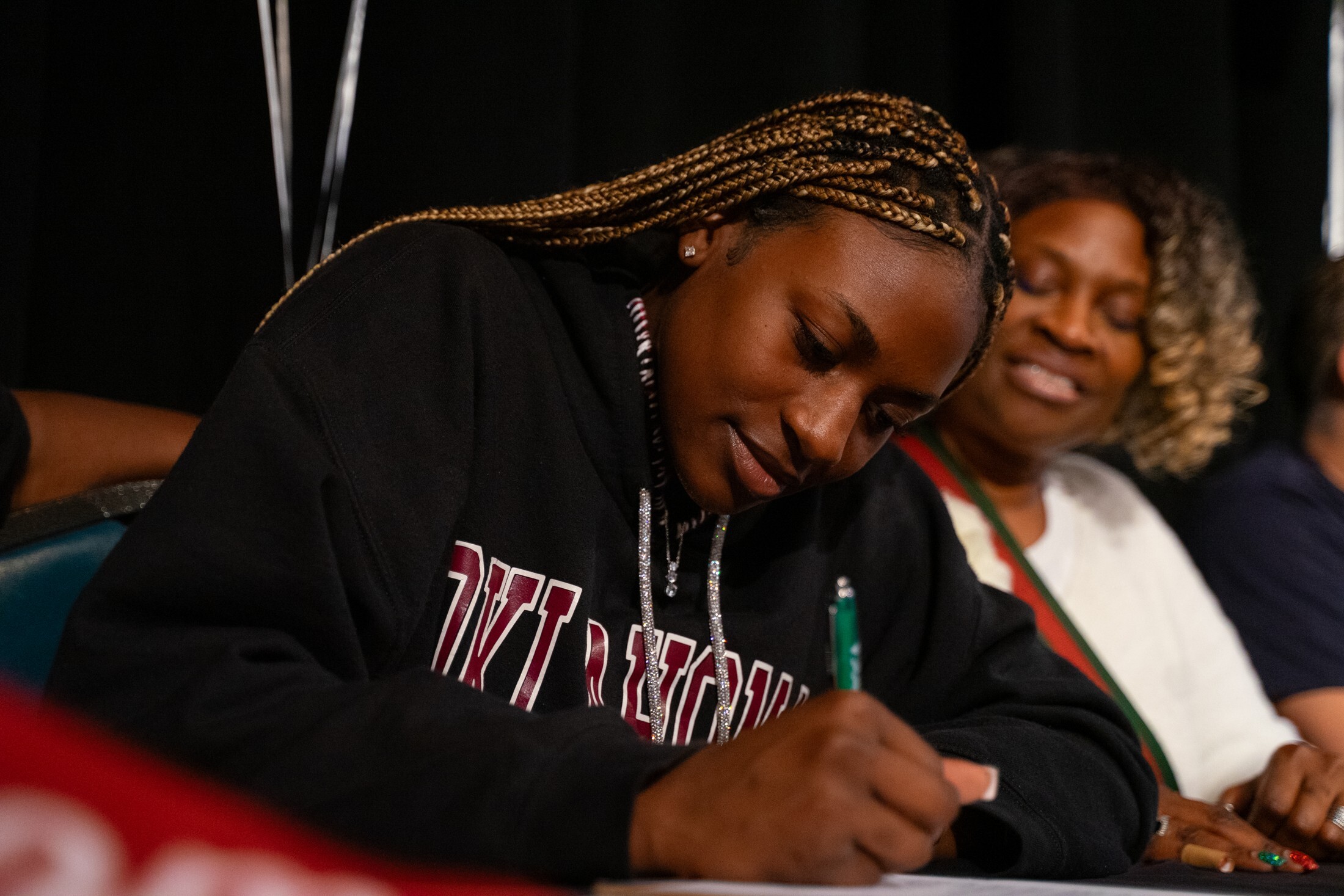 Athlete signing her letter of intent with family beside her