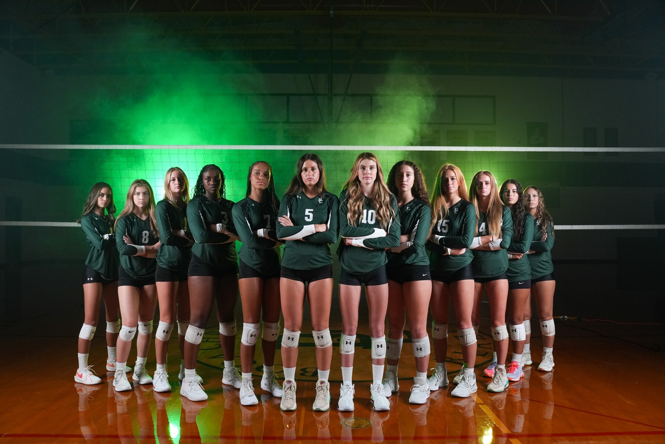 Full team lineup under green media day lights