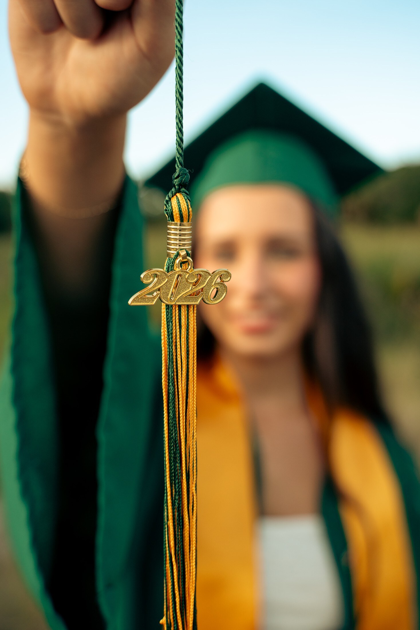 Graduate holding a 2026 tassel in the sun