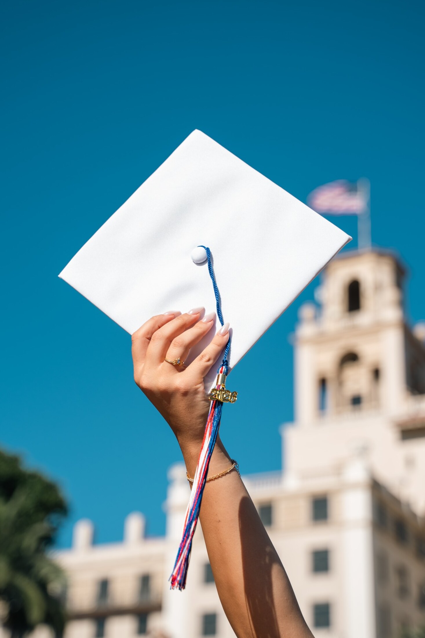 Grad cap held high against the sky