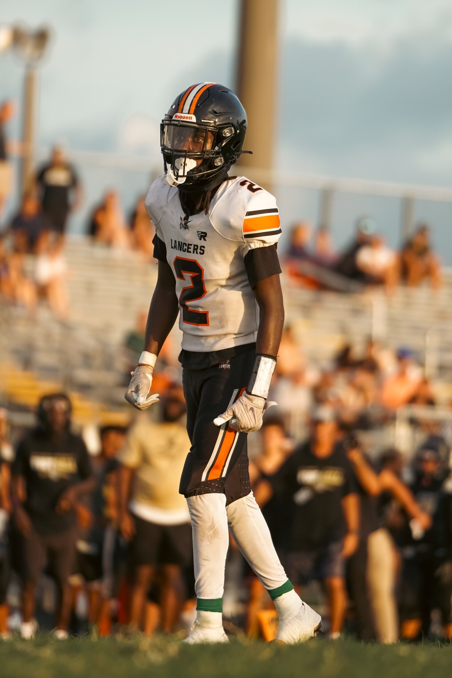 Football player walking the sideline at sunset