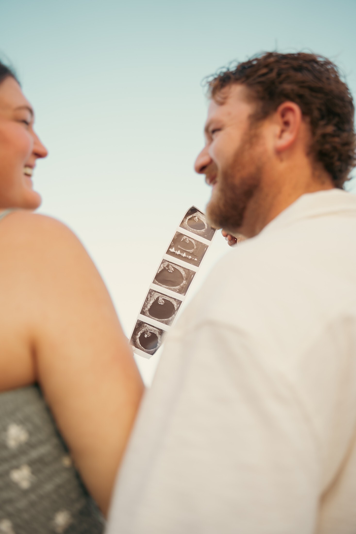 Couple laughing together, film frames in hand