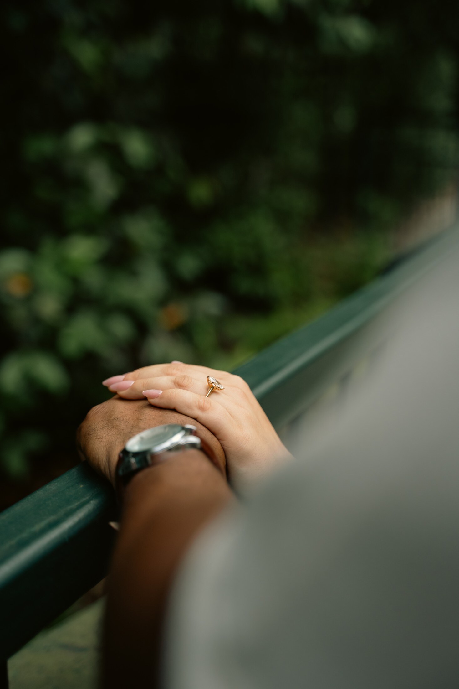 The ring framed between the couple at sunset